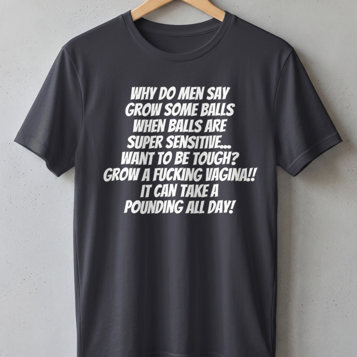 Dark gray t-shirt with white text: "Why do men say grow some balls when balls are super sensitive..."
