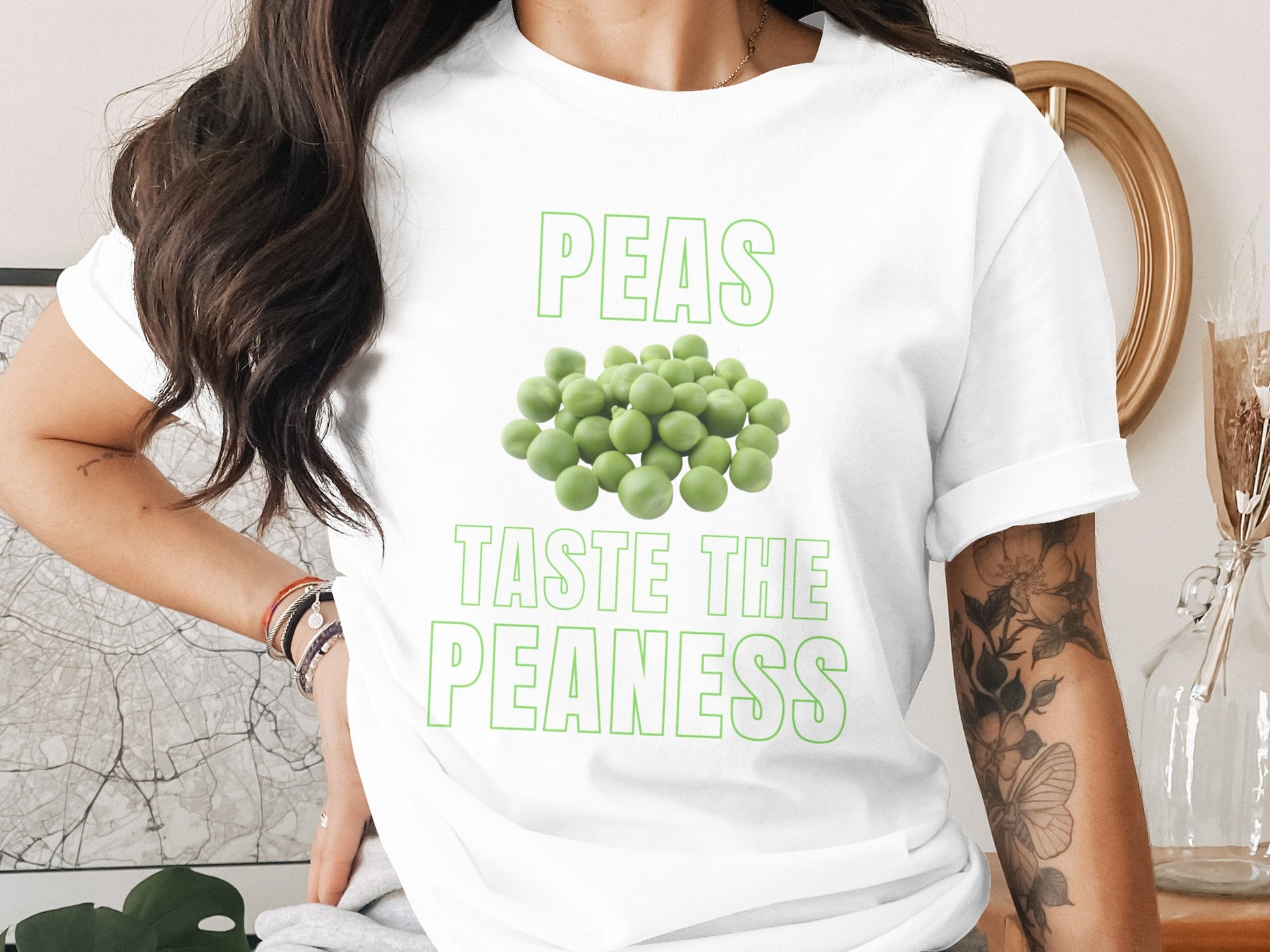 White t-shirt with green text "PEAS TASTE THE PEANESS" and pile of peas.