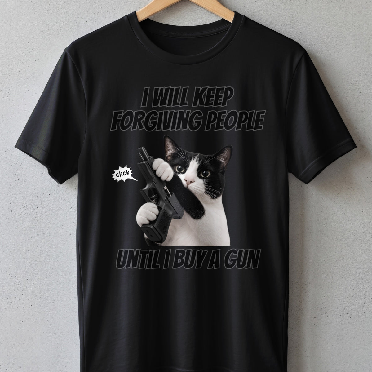 Black t-shirt with a cat holding a gun and text "I will keep forgiving people until I buy a gun".