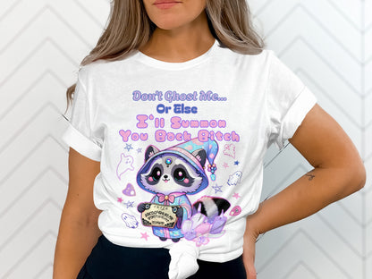 White t-shirt with a raccoon holding Ouija board, ghosts and text.