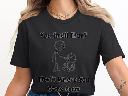 Black t-shirt with line drawing of stick figure touching baby's nose. Text reads "You Smell That? That's Where You Came From".