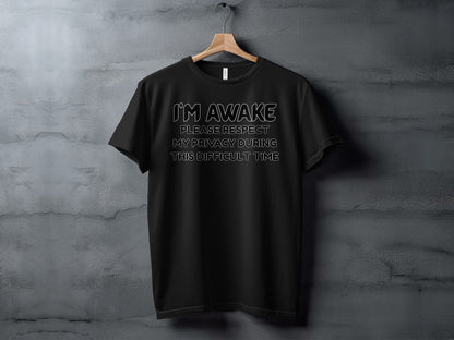 Black t-shirt with white text reading "I'M AWAKE PLEASE RESPECT MY PRIVACY DURING THIS DIFFICULT TIME".