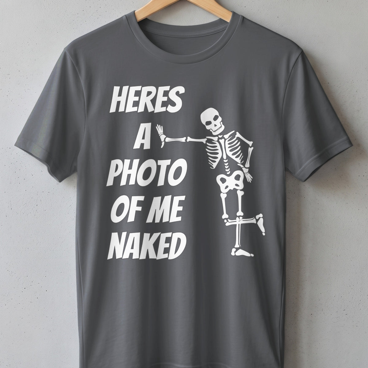 Dark grey t-shirt with white text "HERES A PHOTO OF ME NAKED" and a skeleton graphic.