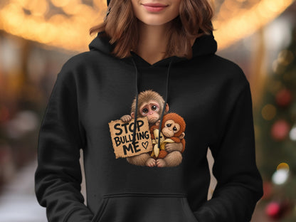 Two monkeys holding a sign that says "Stop Bullying Me" with a banana.