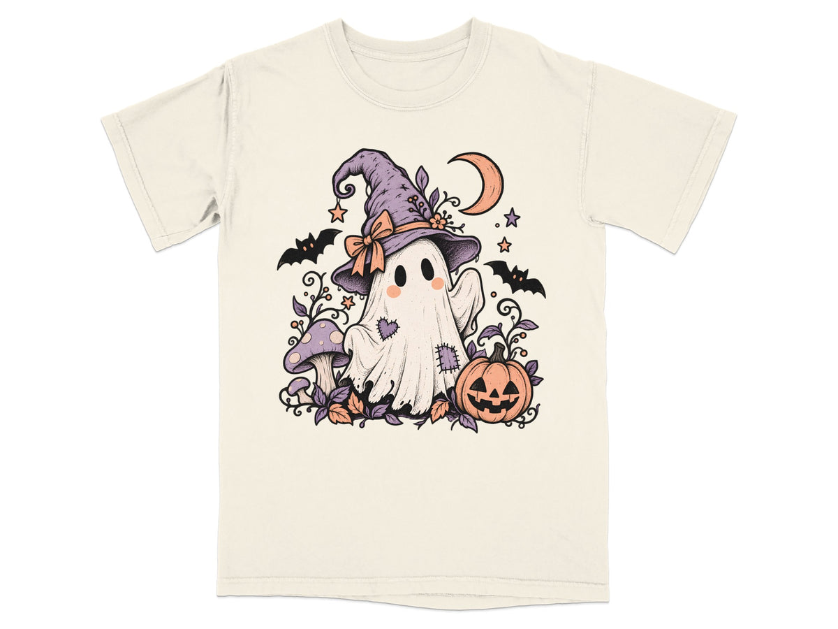 A cream-colored t-shirt with a vintage Halloween illustration of a ghost in a witch hat, pumpkin, and bats.