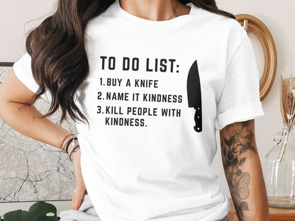 White t-shirt with "TO DO LIST: 1. BUY A KNIFE 2. NAME IT KINDNESS 3. KILL PEOPLE WITH KINDNESS."