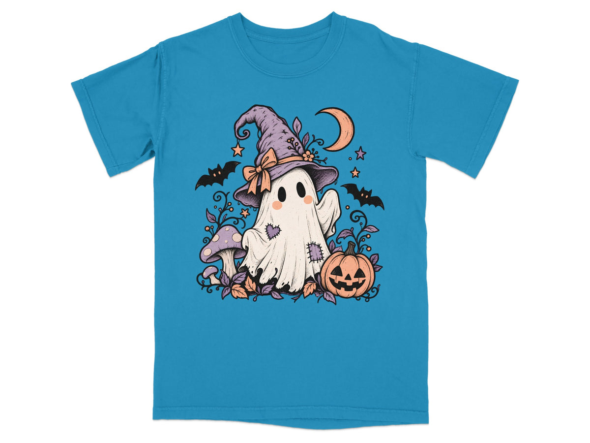 Cartoon ghost with witch hat, bats, pumpkin, mushrooms, and moon on a blue t-shirt.