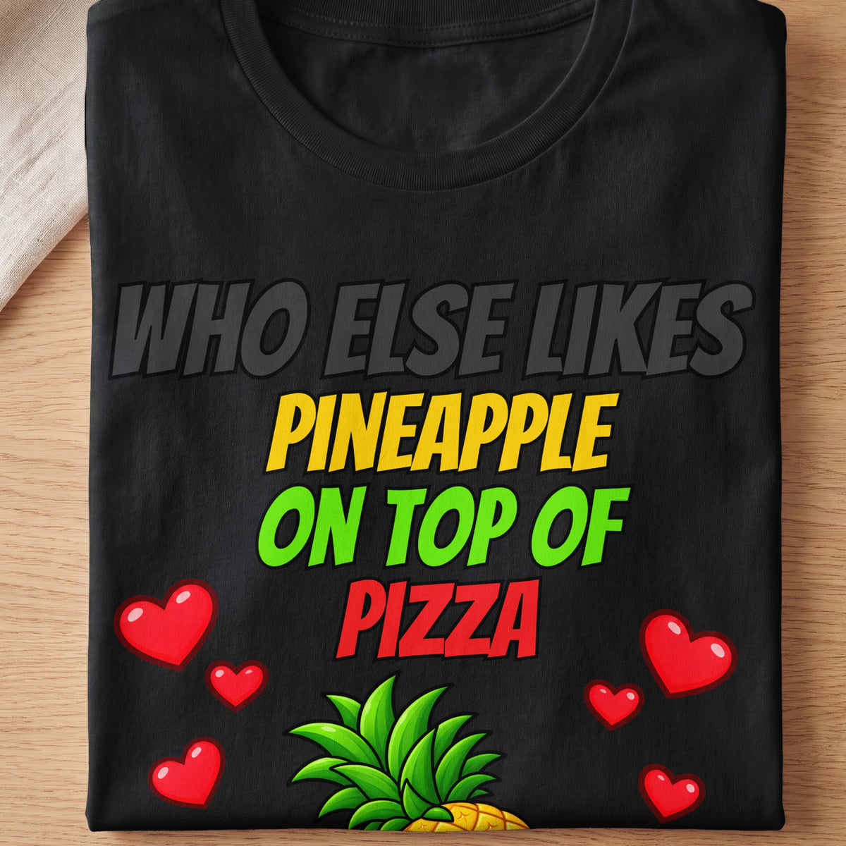 Black t-shirt with text "WHO ELSE LIKES PINEAPPLE ON TOP OF PIZZA".