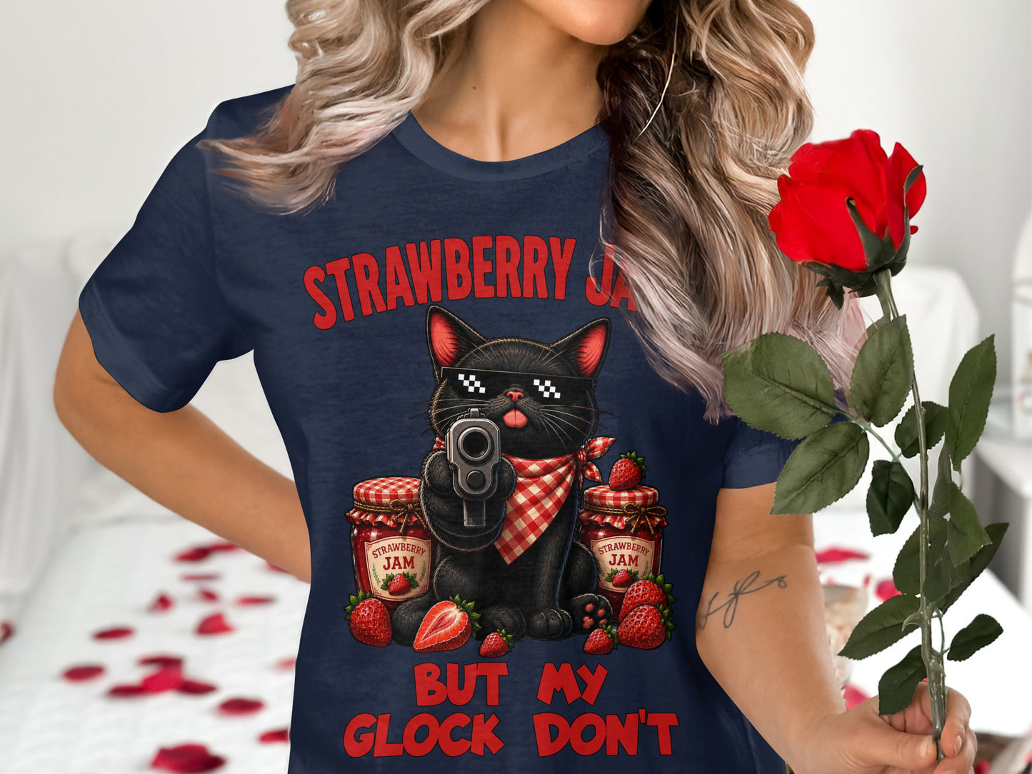 T-shirt graphic of a black cat with sunglasses holding a gun, surrounded by strawberry jam jars and strawberries.