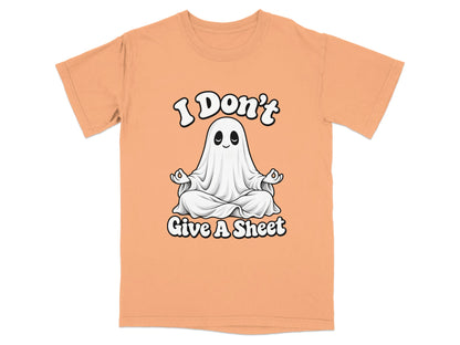 Peach t-shirt with a meditating ghost graphic that says "I Don't Give A Sheet."