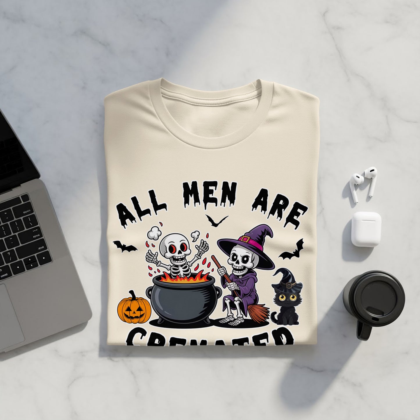 T-shirt graphic with skeletons, black cat, pumpkin, and text "ALL MEN ARE CREATED".