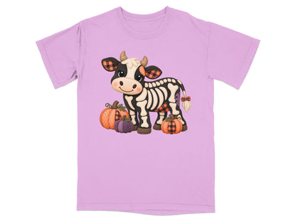 Skeleton cow with plaid accents and pumpkins on a light purple t-shirt.