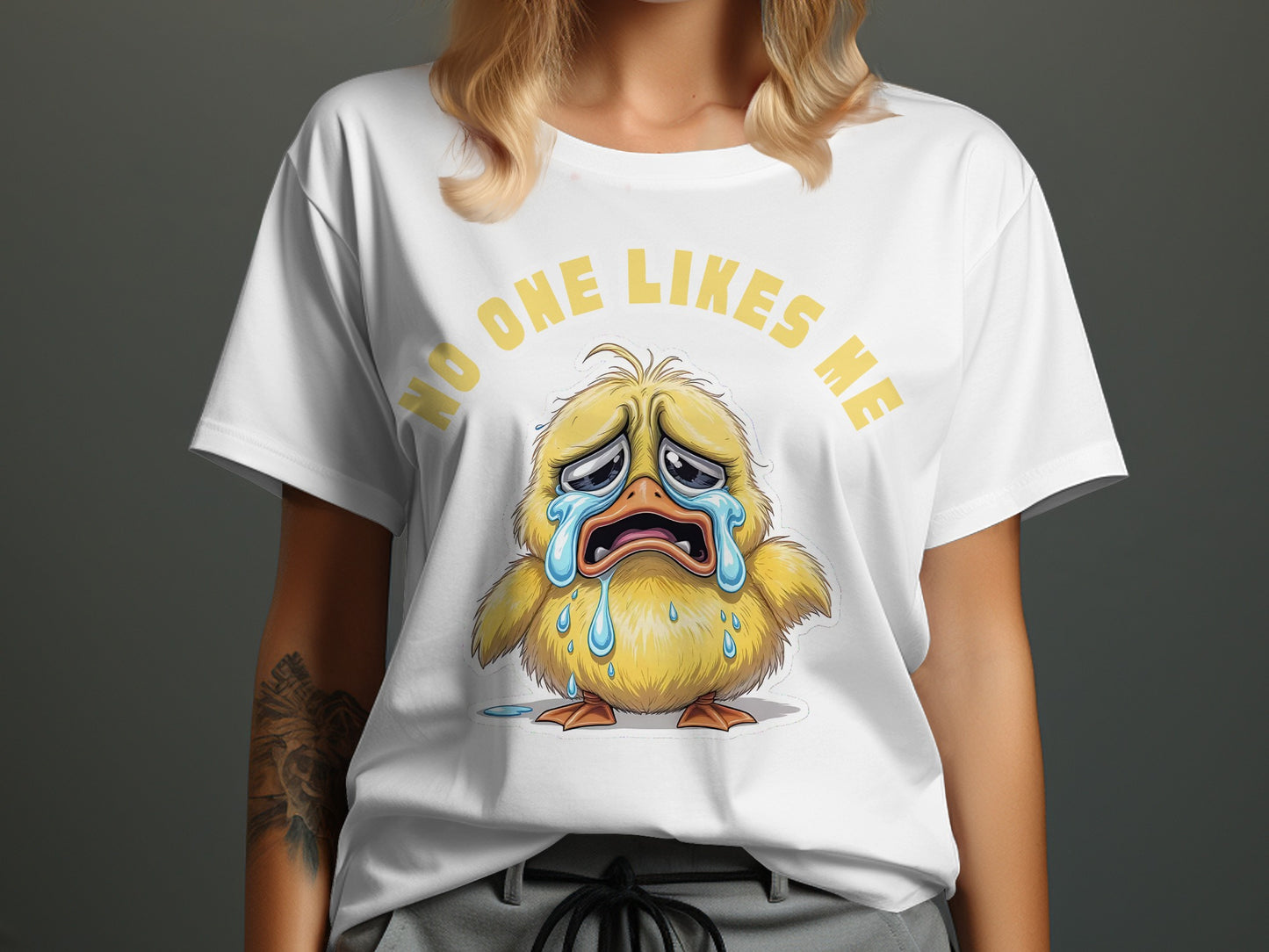 White t-shirt with a cartoon illustration of a crying chick and the text "NO ONE LIKES ME".