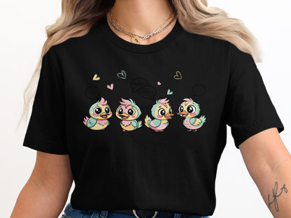 Four colorful cartoon chicks with speech bubbles and hearts on a black t-shirt.
