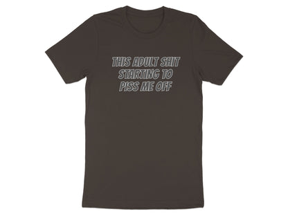 Brown t-shirt with white text reading "THIS ADULT SHIT STARTING TO PISS ME OFF".