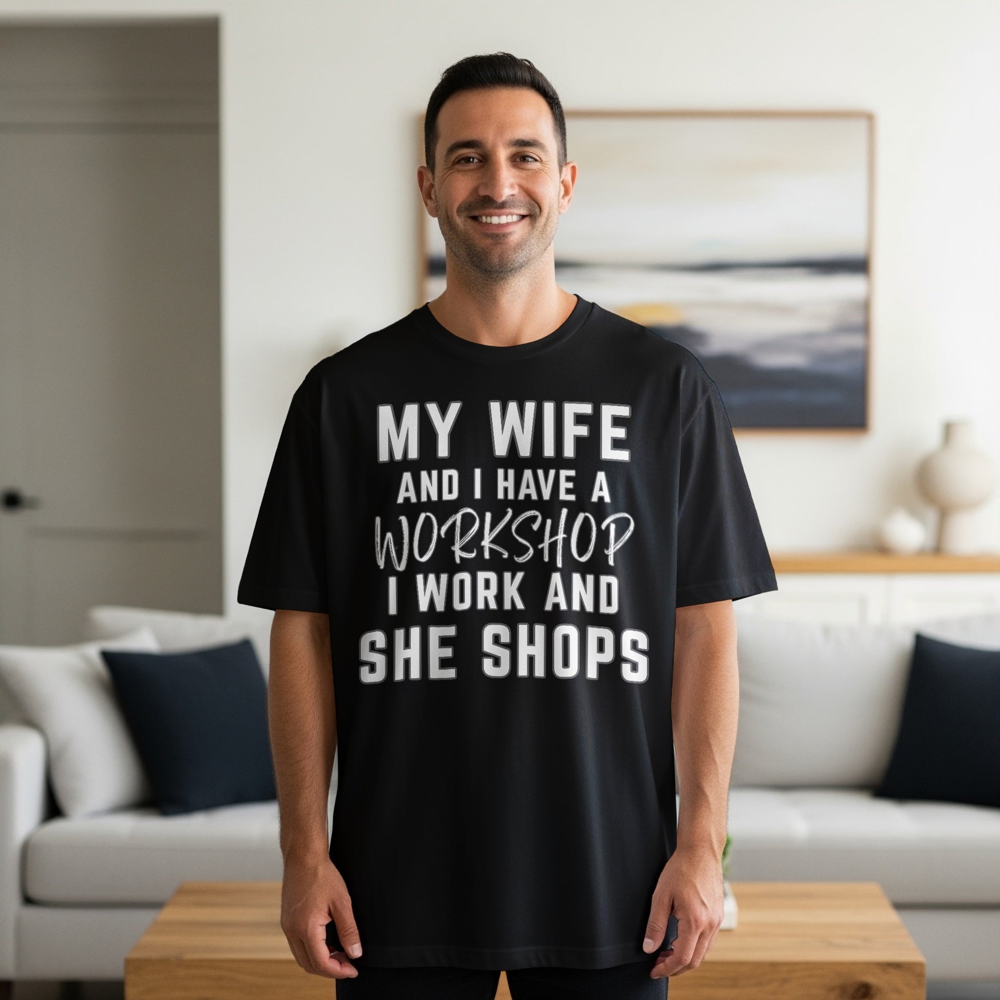 Black t-shirt with white text "My wife and I have a workshop I work and she shops."