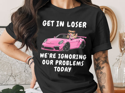 Black t-shirt with text "GET IN LOSER WE'RE IGNORING OUR PROBLEMS TODAY" and a hamster in a pink car.
