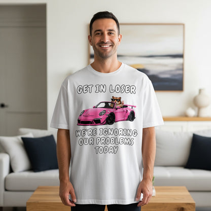 White t-shirt with "Get in loser, we're ignoring our problems today" text and cartoon.