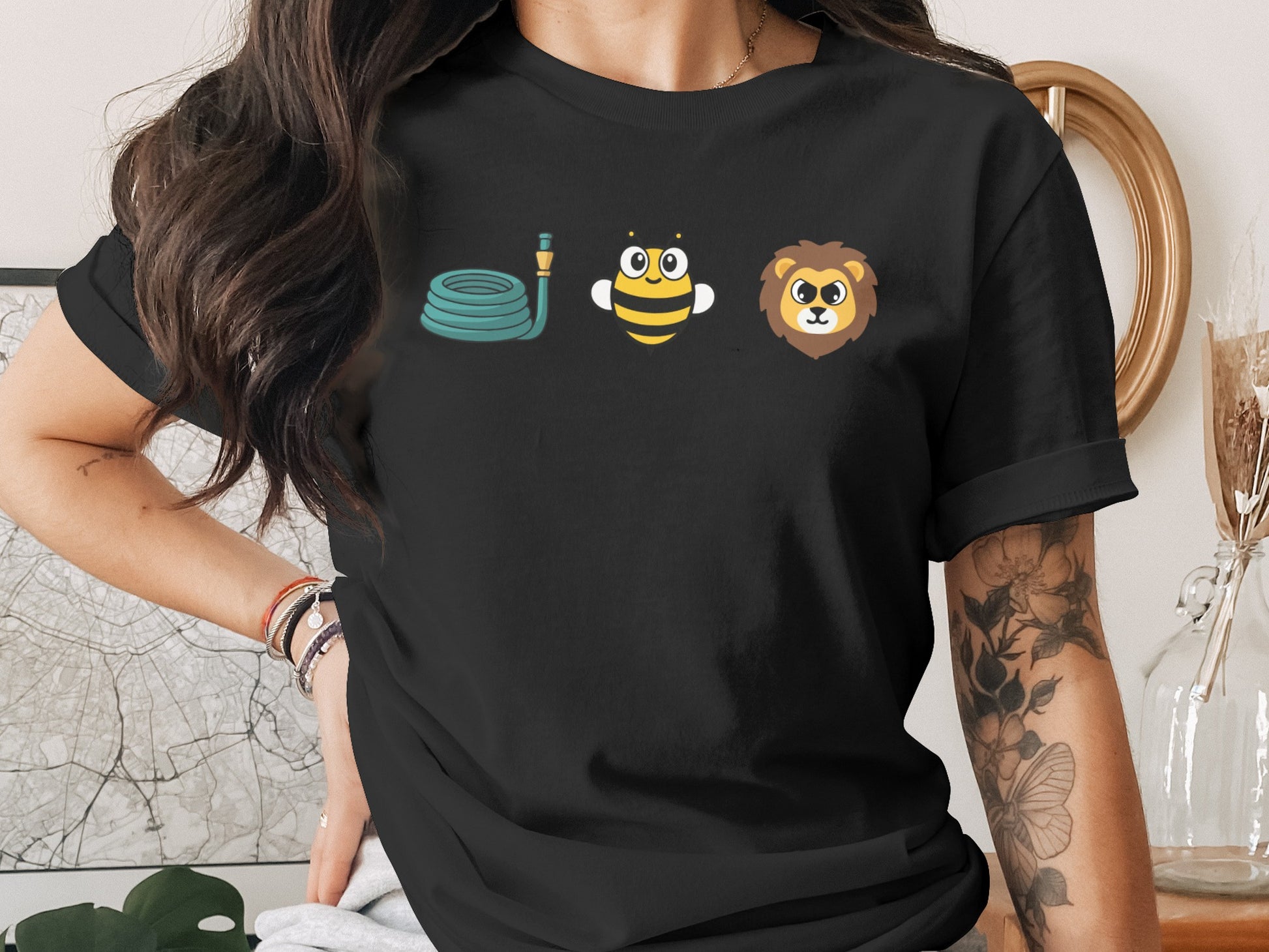 Black t-shirt with a coiled hose, bee, and lion graphic on the chest.