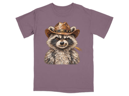 Illustration of a cowboy raccoon with a wheat stalk in its mouth on a purple t-shirt.
