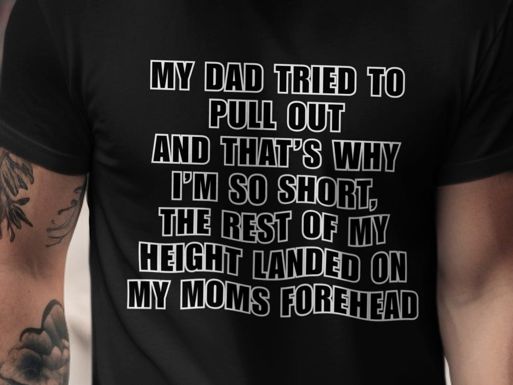 Black t-shirt with white text: "MY DAD TRIED TO PULL OUT AND THAT'S WHY I'M SO SHORT, THE REST OF MY HEIGHT LANDED ON MY MOMS FOREHEAD"