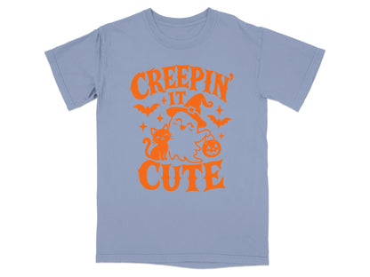 Light blue t-shirt with orange "Creepin' It Cute" Halloween graphic.