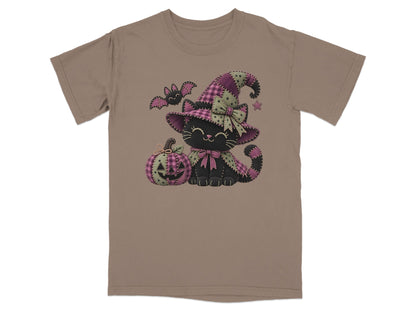 Black cat in witch hat with pumpkin and bat on taupe t-shirt.