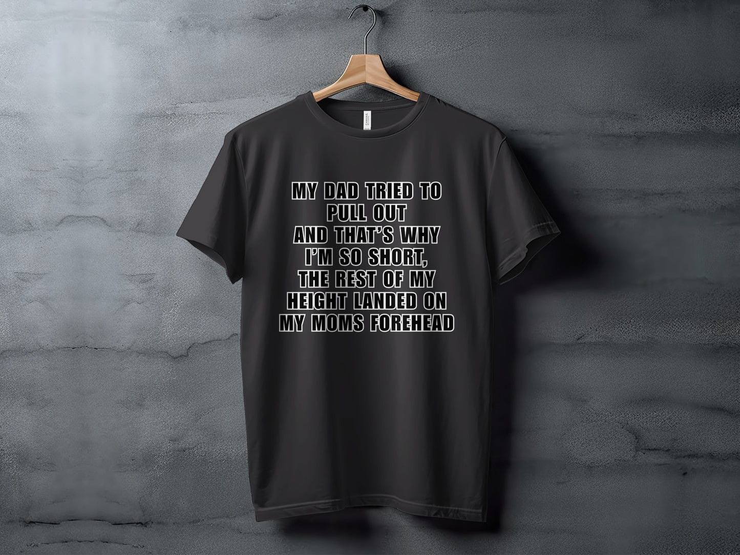 Dark t-shirt with white text reading "My dad tried to pull out and that's why I'm so short, the rest of my height landed on my mom's forehead."