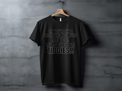 Black t-shirt with white text reading "Oh You're Into Pronouns Too Huh? Me Too! Let Me She/Them Tiddies!!"
