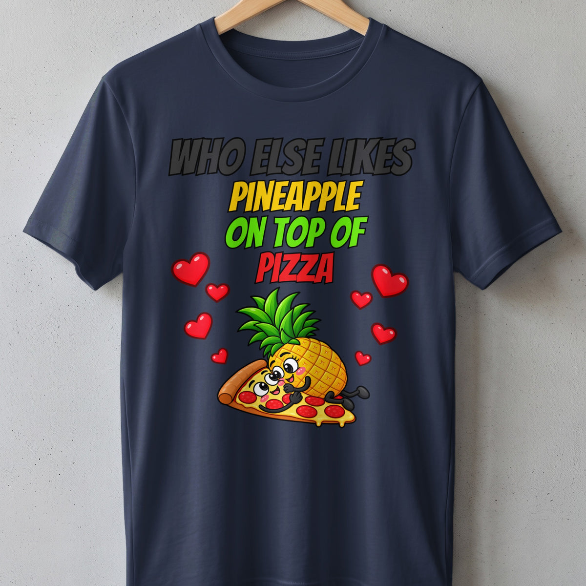 Dark t-shirt with cartoon pineapple on pizza and text "Who Else Likes Pineapple On Top Of Pizza".