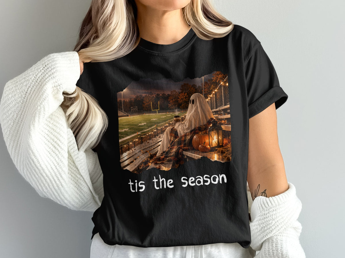 Black t-shirt with a graphic of a ghost on stadium bleachers, autumn scene, and text "tis the season."