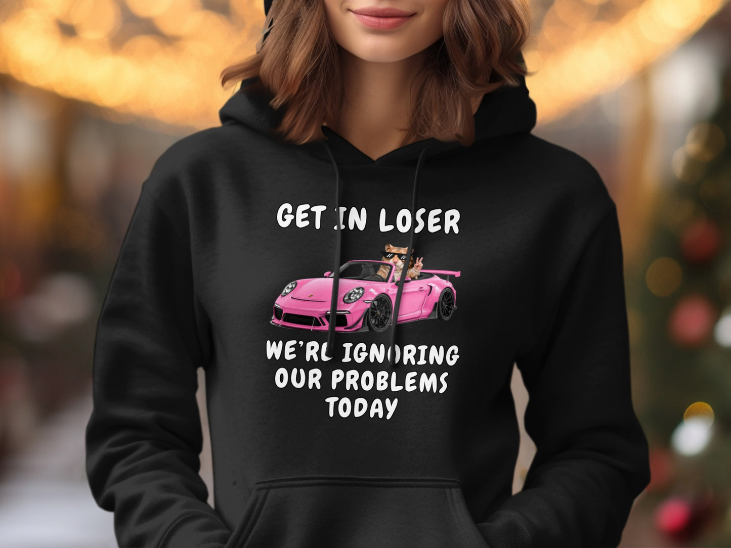 Black hoodie with text and cartoon of cats in a pink car.