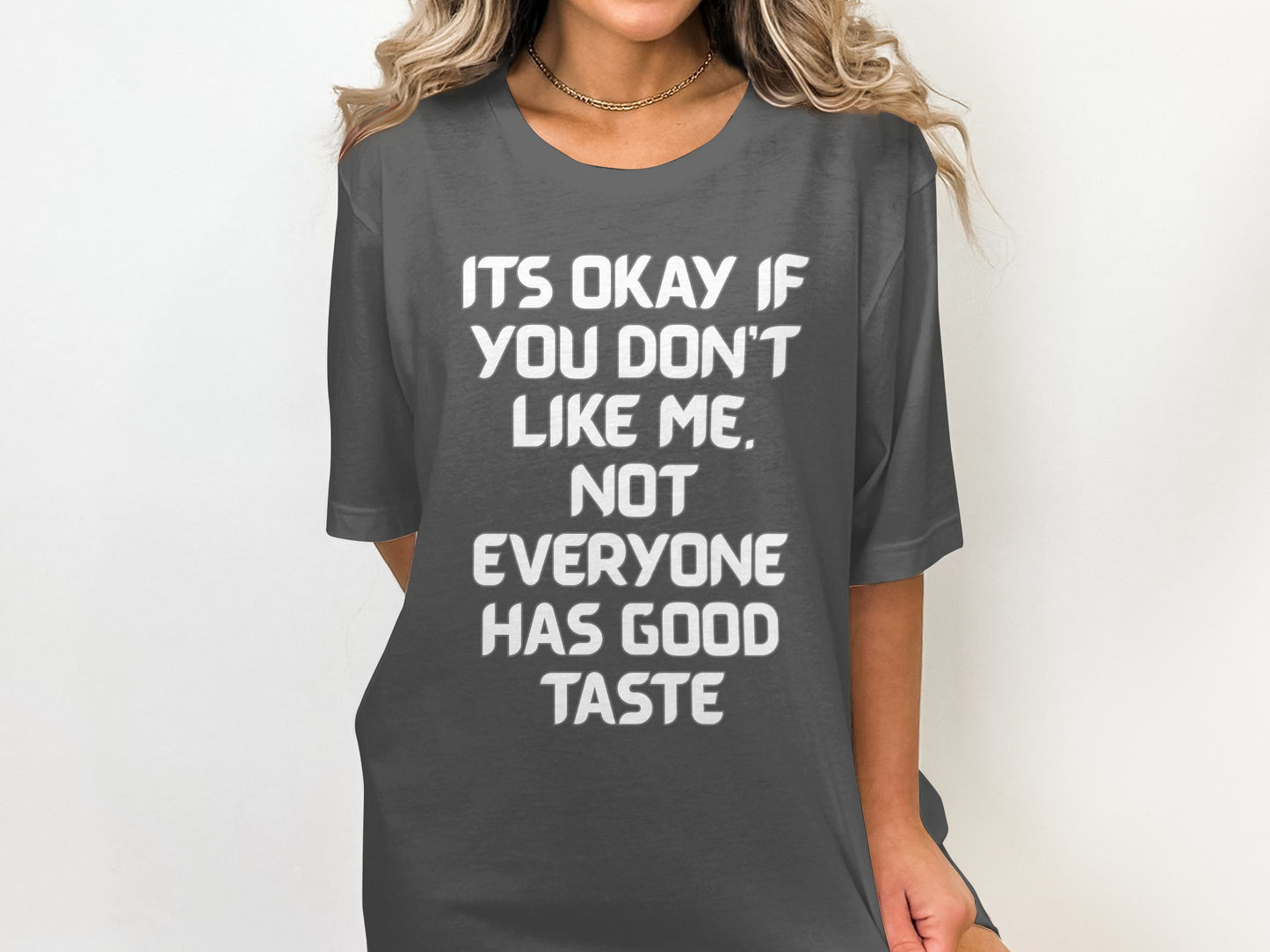 Dark grey t-shirt with white text "ITS OKAY IF YOU DON'T LIKE ME. NOT EVERYONE HAS GOOD TASTE".