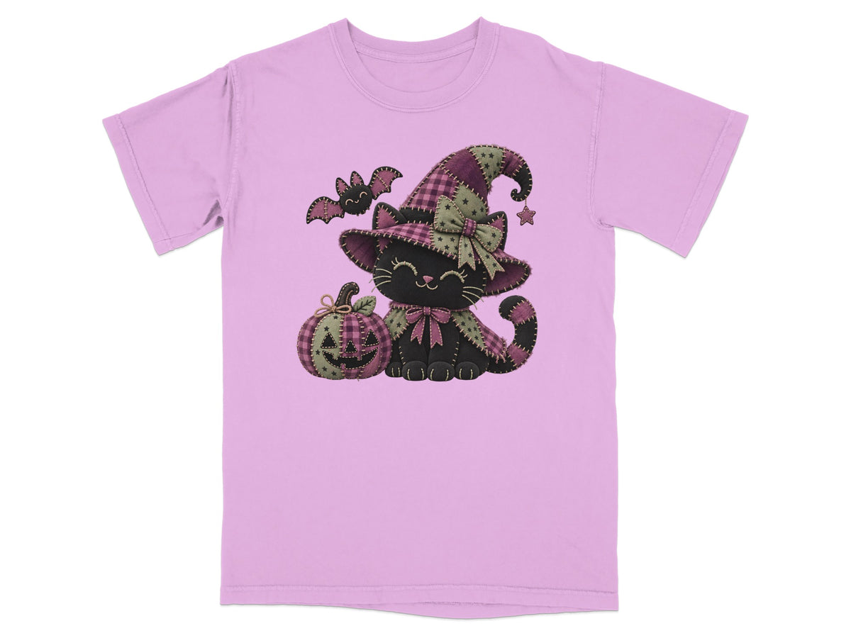 Black cat wearing a witch hat with pumpkin and bat, on a pink t-shirt.