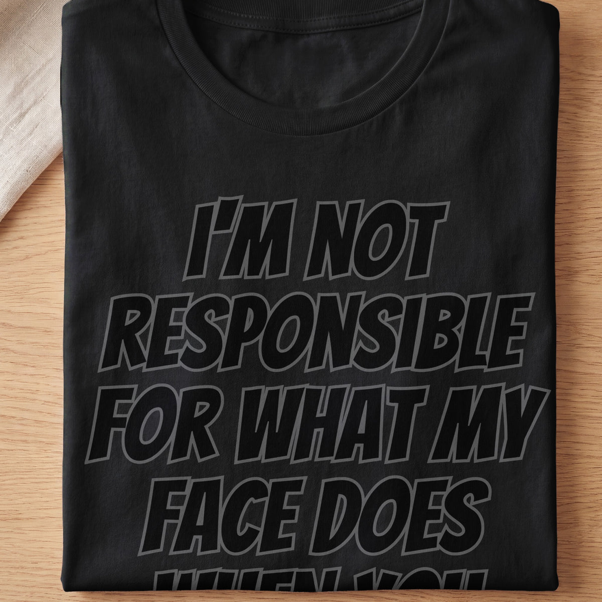 Black t-shirt with gray text that reads "I'M NOT RESPONSIBLE FOR WHAT MY FACE DOES".