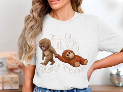 White t-shirt graphic: monkey pulling along a slumped orangutan with text "I'm Not Okay Today".