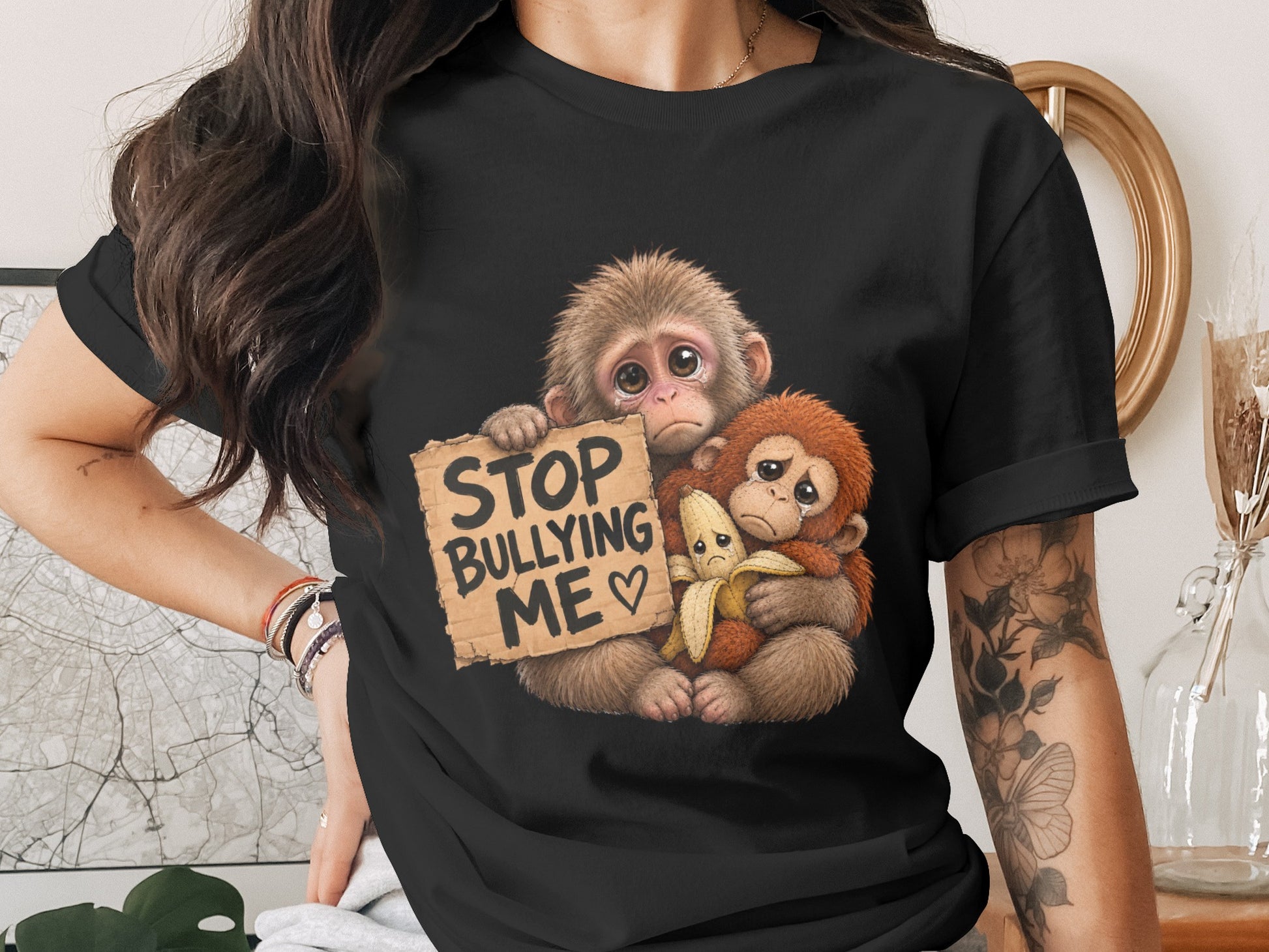 Two sad monkeys holding a sign that reads "STOP BULLYING ME" and a banana.