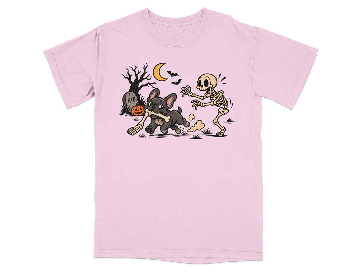 A light pink t-shirt featuring a graphic of a skeleton chasing a French bulldog holding a bone.