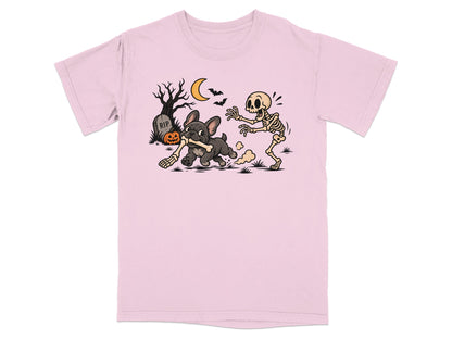 A light pink t-shirt featuring a graphic of a skeleton chasing a French bulldog holding a bone.