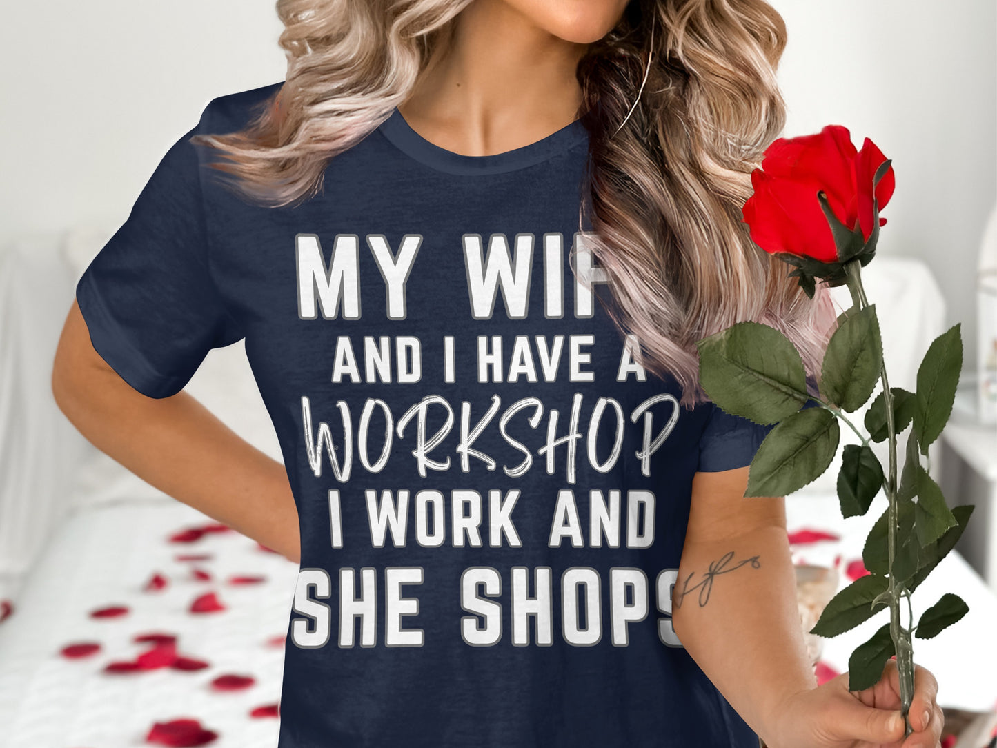 Dark blue t-shirt with white text: "MY WIFE AND I HAVE A WORKSHOP, I WORK AND SHE SHOPS."