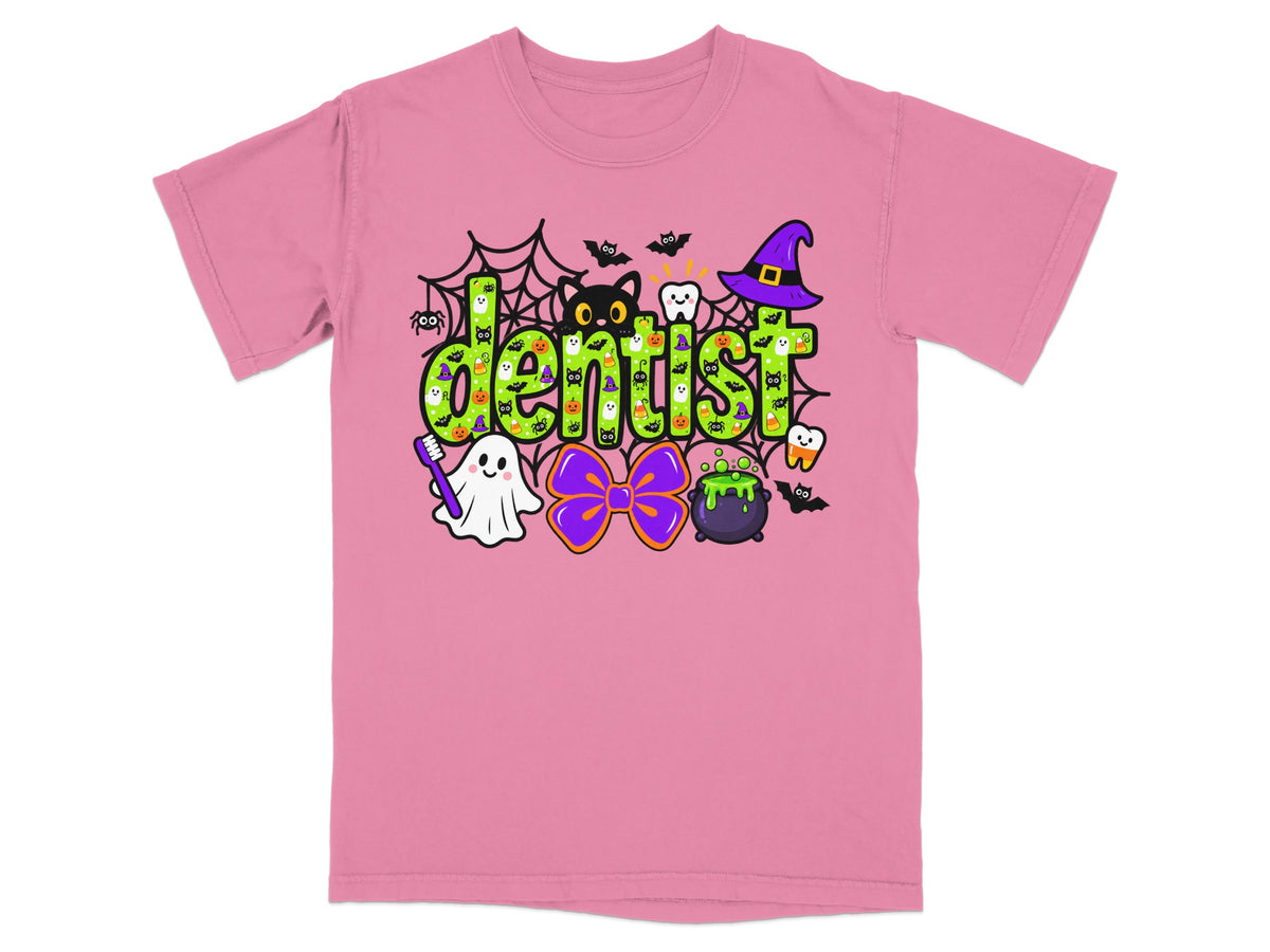 Pink t-shirt with a green Halloween graphic reading dentist, surrounded by ghosts, cats, and witch hats.
