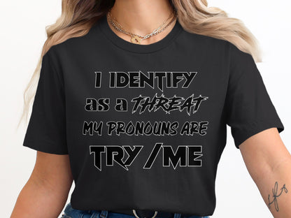 Black t-shirt with the text "I identify as a threat. My pronouns are try/me."