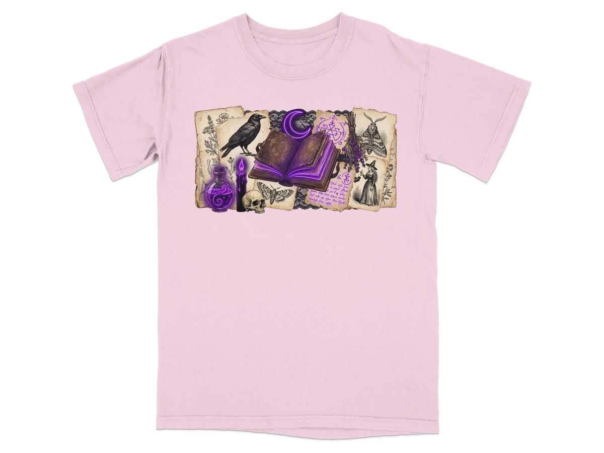 Pink t-shirt with witchy illustration featuring a crow, spellbook, potion, and moths.