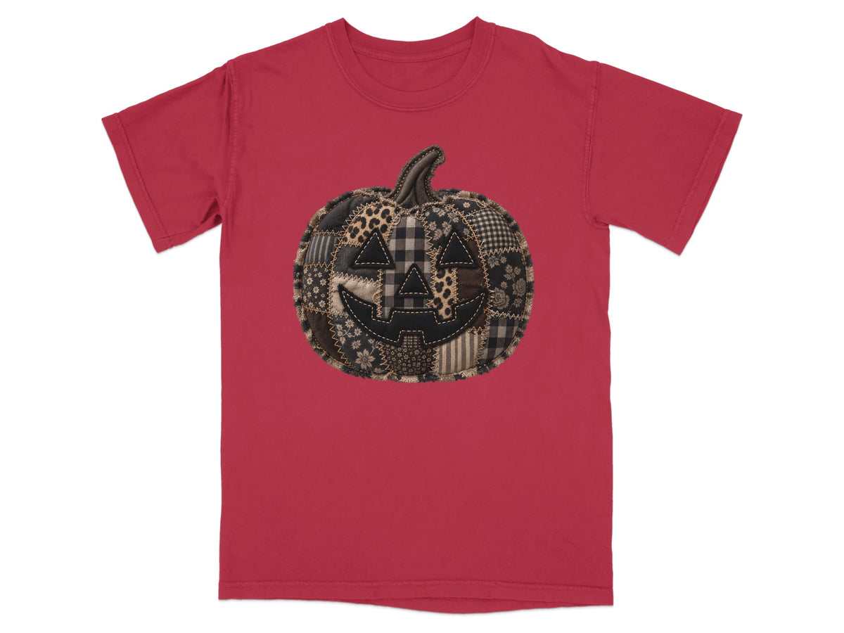 Red t-shirt with a stitched patchwork pumpkin jack-o'-lantern graphic.