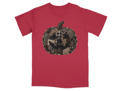 Red t-shirt with a stitched patchwork pumpkin jack-o'-lantern graphic.