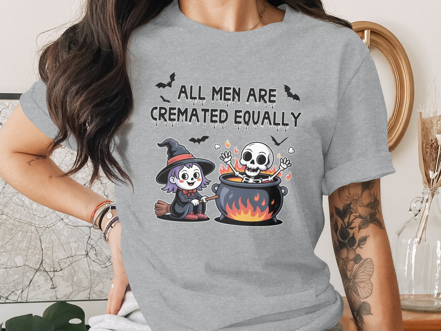 Gray t-shirt with Halloween graphic "All Men Are Cremated Equally" and cartoon witch and skeleton.