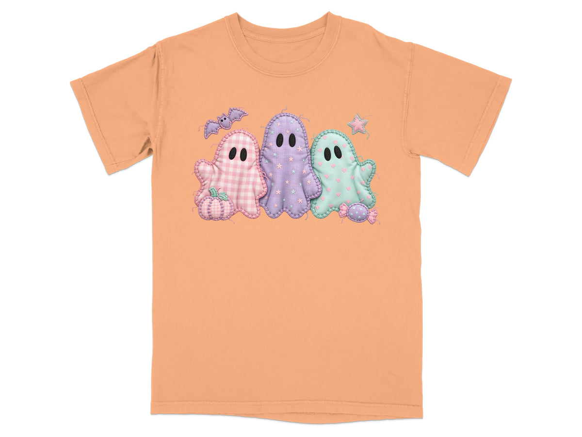 Orange t-shirt with three pastel ghost appliques and Halloween elements.