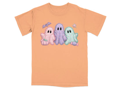 Orange t-shirt with three pastel ghost appliques and Halloween elements.