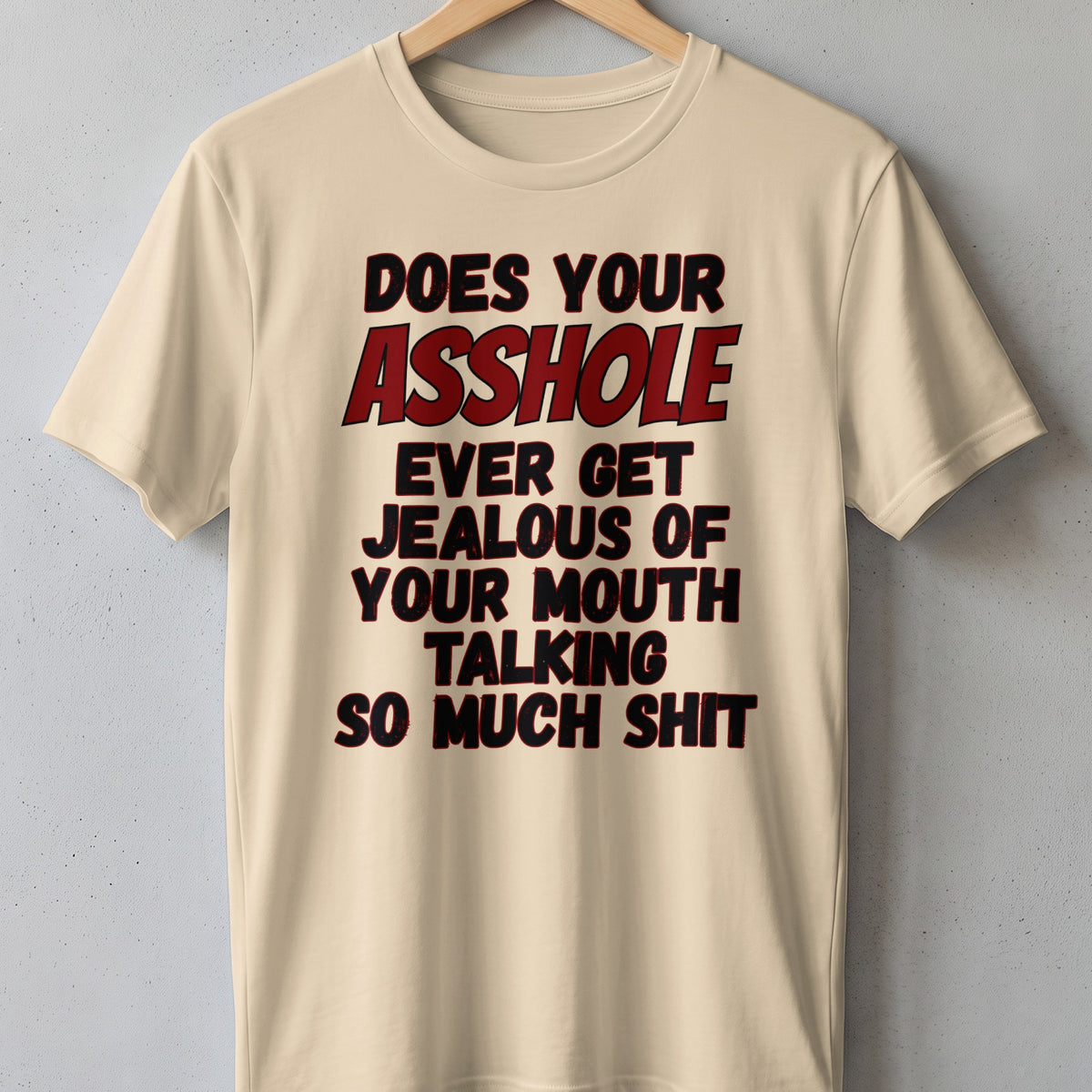 Beige t-shirt with black and red text reading "DOES YOUR ASSHOLE EVER GET JEALOUS OF YOUR MOUTH TALKING SO MUCH SHIT".
