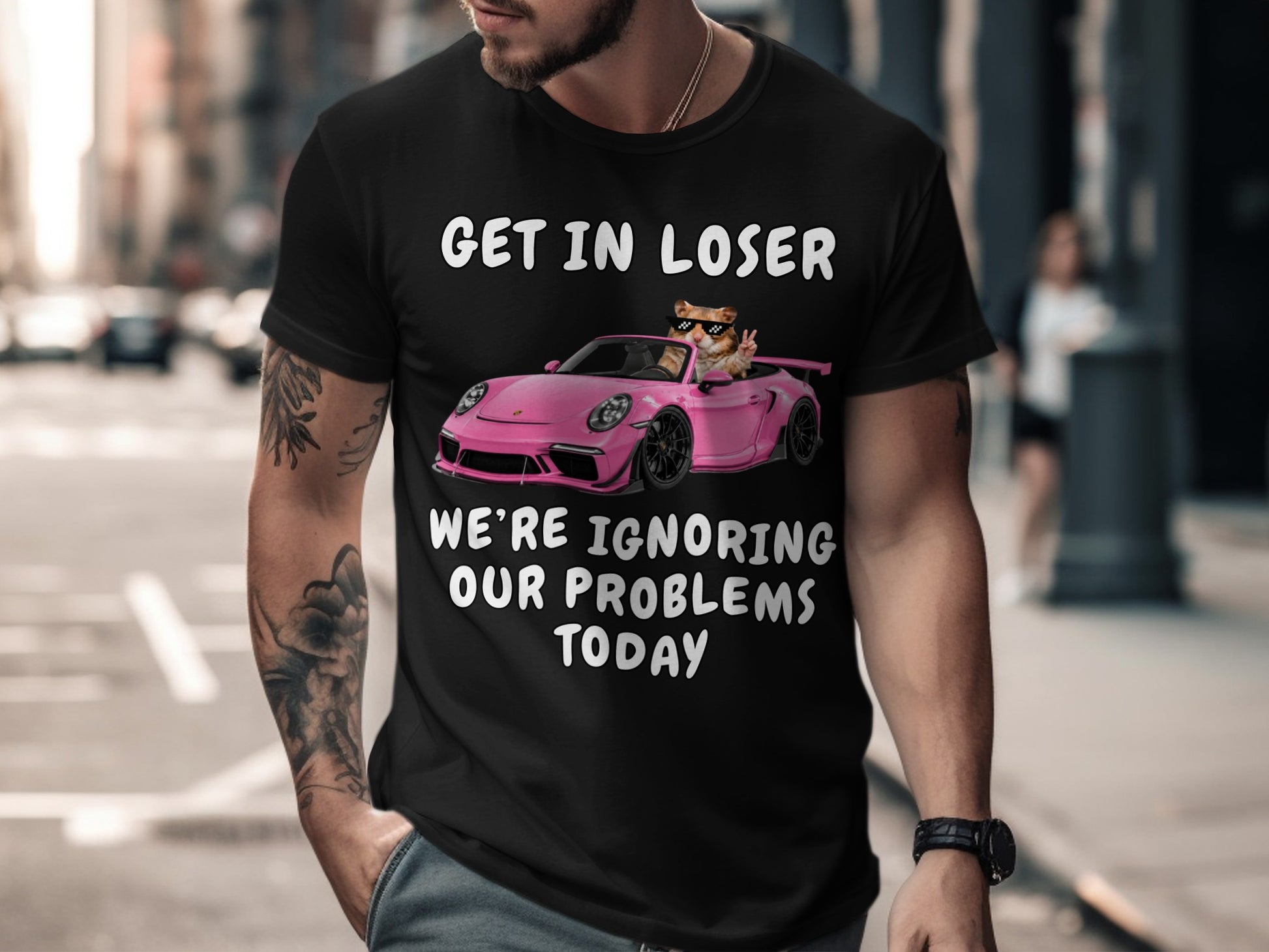 Black t-shirt with cat in pink car graphic and text "GET IN LOSER WE'RE IGNORING OUR PROBLEMS TODAY".